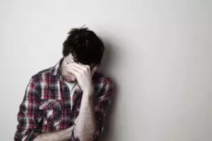 man sitting against a wall has meth addiction