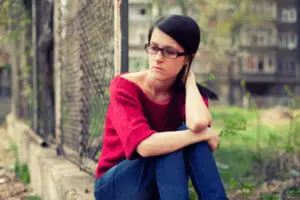 woman sitting on curb needs relapse prevention