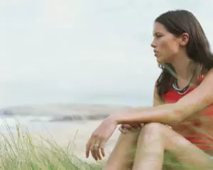 woman sitting on beach considers seeking addiction help