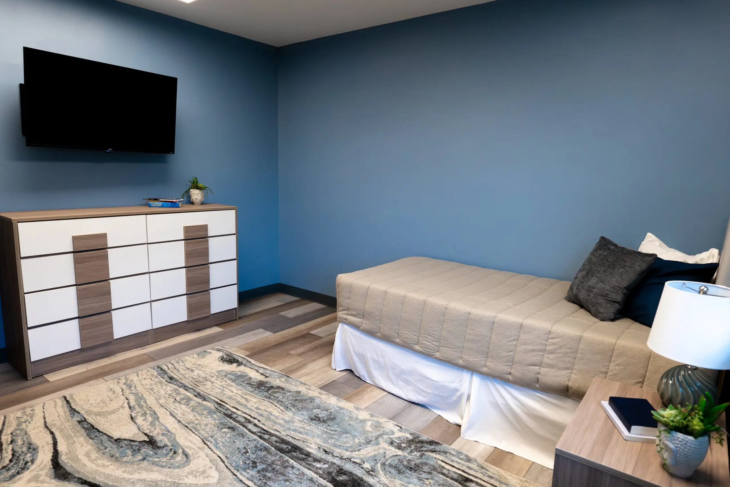 bed, tv, and cabinents in inpatient rehab bedroom